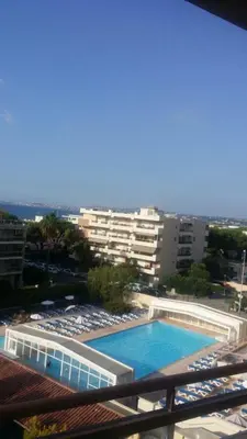 a view of a swimming pool from the balcony of a building at Appartement Nice aéroport seafront with pool in Cros-de-Cagnes