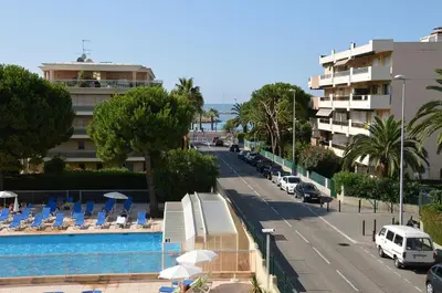 a view of a street with a pool and a building at Appartement Nice aéroport seafront with pool in Cros-de-Cagnes