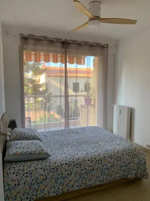 a bedroom with a bed and a large window at Agréable 2 pièces à 150 m de la mer in Cagnes-sur-Mer