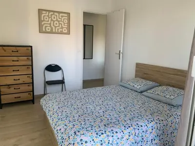 a bedroom with a bed and a chair and a dresser at Agréable 2 pièces à 150 m de la mer in Cagnes-sur-Mer