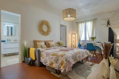 a bedroom with a bed with pink slippers on it at Cosy, modern, fully equipped, air conditioning, Nice historical, old town, 1minute walk from beach - 