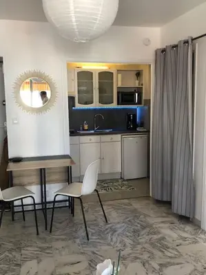 a kitchen with two chairs and a table and a mirror at Vue mer, 2 pièces lumineux in Nice