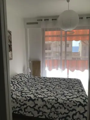 a bedroom with a large bed and a window at Vue mer, 2 pièces lumineux in Nice