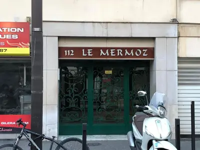 a scooter parked in front of a building with a green door at Vue mer, 2 pièces lumineux in Nice