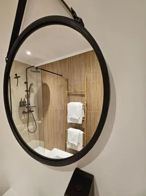 a mirror reflecting a bathroom with a shower and a sink at Studio Saint-Laurent-Du-Var bord de mer in Saint-Laurent-du-Var