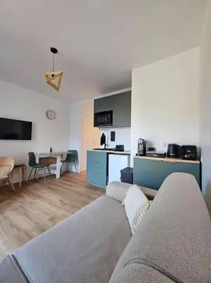 a living room with a couch and a kitchen at Studio Saint-Laurent-Du-Var bord de mer in Saint-Laurent-du-Var