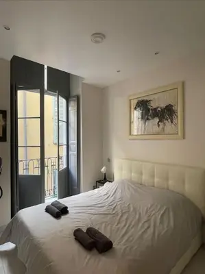 a bedroom with a large bed with two slippers on it at Luxury apartment In the heart of old town Nice. in Nice