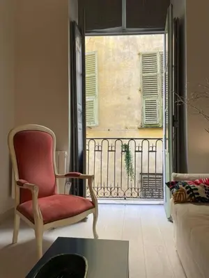 a living room with a red chair and a window at Luxury apartment In the heart of old town Nice. in Nice