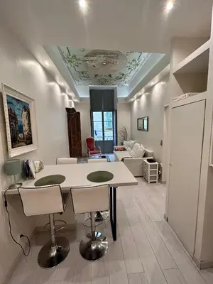 a kitchen and living room with a table and chairs at Luxury apartment In the heart of old town Nice. in Nice