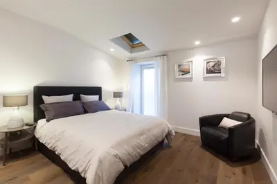 a bedroom with a bed and a chair and a window at Duplex Nice Avenue Jean-Médecin in Nice