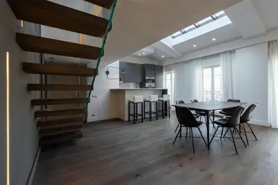 a dining room and kitchen with a table and chairs at Duplex Nice Avenue Jean-Médecin in Nice