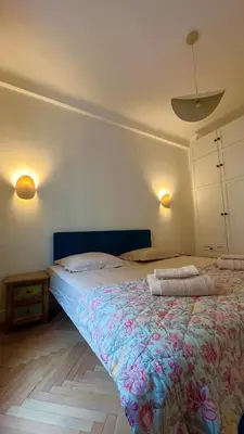 a bedroom with a large bed with a floral blanket at CHEZ TAMARA in Nice