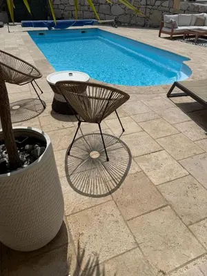 a swimming pool with a table and a chair next to a pool at Bas de Villa à 15 min de Nice avec piscine in Carros