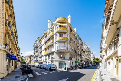 a tall white building on a city street with parked cars at Nice Renting - OFFENBACH - Luxury Apartment Fully Equipped Center in Nice