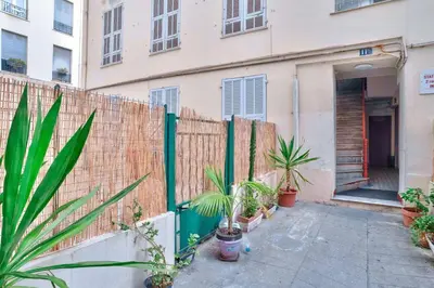 a fence with plants in front of a building at Nidusudest - Spacieux appartement in Nice