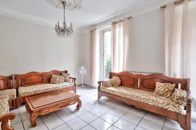 a living room with two wooden couches and a table at Nidusudest - Spacieux appartement in Nice
