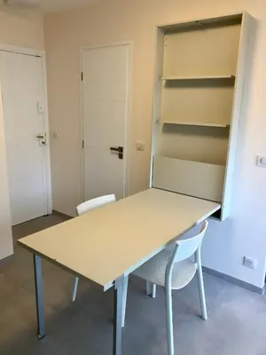 a table and chairs in a room with shelves at Studios Nice Gambetta in Nice