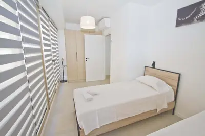 a white bedroom with a bed and a hallway at Sea Front Palace Promenade in Nice