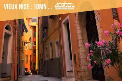 an alley in an old town with pink flowers at Studio cozy et moderne dans résidence à Nice in Nice