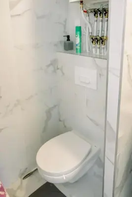 a white bathroom with a toilet and a white marble wall at Studio cozy et moderne dans résidence à Nice in Nice
