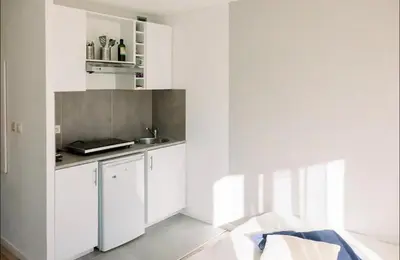 a kitchen with white cabinets and a sink at Studio cozy et moderne dans résidence à Nice in Nice