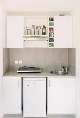 a kitchen with white cabinets and a sink at Studio cozy et moderne dans résidence à Nice in Nice
