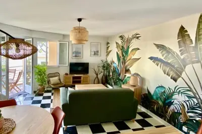 a living room with a green couch and some plants at Beautiful flat with balcony and sea view in Saint-Laurent-du-Var
