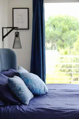 a bedroom with a bed with pillows and a window at Beautiful flat with balcony and sea view in Saint-Laurent-du-Var