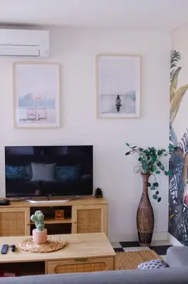 a living room with a tv and a table at Beautiful flat with balcony and sea view in Saint-Laurent-du-Var