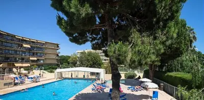 a swimming pool with chairs and a tree and a building at Résidence Héliotel Marine - maeva Home - Studio 4 personnes - Confort MAE-5084 in Cros-de-Cagnes