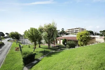 a park with green grass and trees on the side of a road at Résidence Héliotel Marine - maeva Home - Studio 4 personnes - Confort MAE-5084 in Cros-de-Cagnes