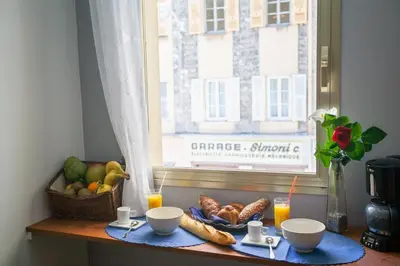 a table with food and a window with a basket of fruit at Appartement 3 pièces SoNice au centre de Nice in Nice
