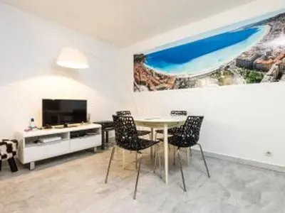 a dining room with a table and chairs and a tv at Appartement 3 pièces SoNice au centre de Nice in Nice