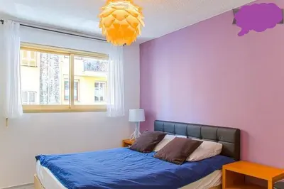 a bedroom with a bed and a purple wall at Appartement 3 pièces SoNice au centre de Nice in Nice