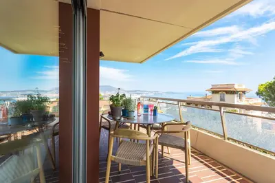 a balcony with a table and chairs and a view of the ocean at BELLES TERRES AP4378 By Riviera Holiday Homes in Nice