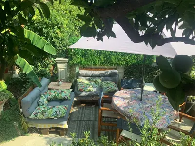a patio with couches and a table and an umbrella at Douceur d'Azur in Nice