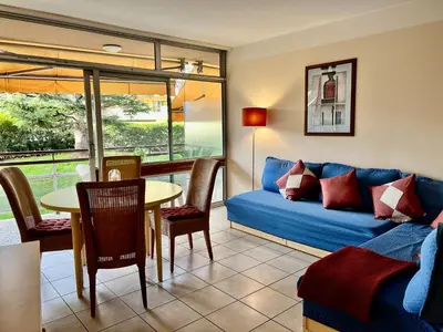 a living room with a blue couch and a table at Nice Seaside Pool and Tennis in Nice