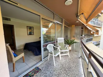 a balcony of a house with two chairs and a bed at Nice Seaside Pool and Tennis in Nice