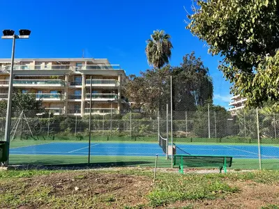 a tennis court in front of a building at Nice Seaside Pool and Tennis in Nice