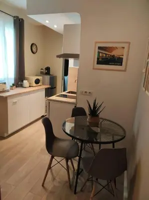 a kitchen with a table and chairs in a room at «l’Orient Express» joli 2 pièces fonctionnel in Nice