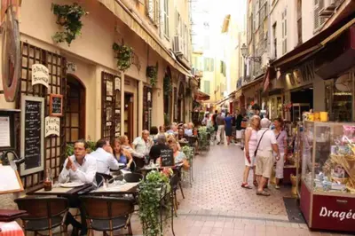 a group of people sitting at tables in a street at Studio de charme au coeur de la vieille ville in Nice