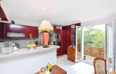 a kitchen with red cabinets and a table with a lamp at Awesome Apartment In Cagnes-Sur-Mer in Cagnes-sur-Mer