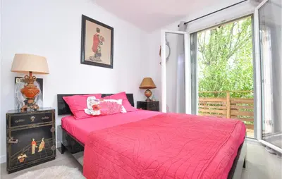 a bedroom with a pink bed and a window at Awesome Apartment In Cagnes-Sur-Mer in Cagnes-sur-Mer