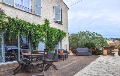 a patio with chairs and a table on a deck at Awesome Apartment In Cagnes-Sur-Mer in Cagnes-sur-Mer