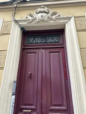a burgundy door with avisor above it on a building at Beau studio au cœur de Nice in Nice