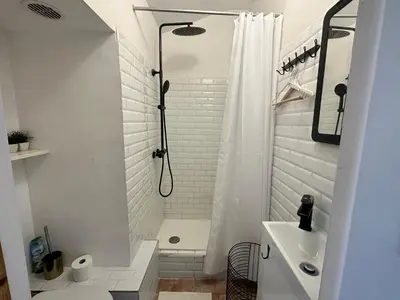 a white bathroom with a shower and a sink at Beau studio au cœur de Nice in Nice