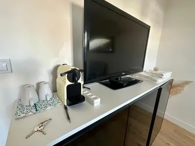 a desk with a monitor and a keyboard and a computer on it at Beau studio au cœur de Nice in Nice