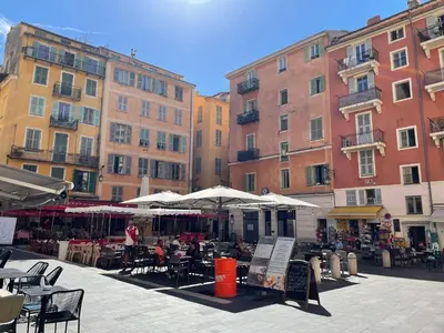 a group of buildings with tables and chairs and umbrellas at Old Town Nice Place Rossetti Themed 2BR Apartment Full Air Conditioning in Nice