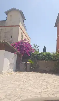 a building with pink flowers in front of it at Cabane pas loin de la plage in Cagnes-sur-Mer