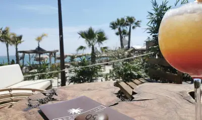 a glass of wine sitting on a table with a view of the ocean at Cabane pas loin de la plage in Cagnes-sur-Mer